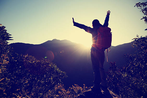 istock successful woman hiker open arms on sunrise mountain peak 511487314