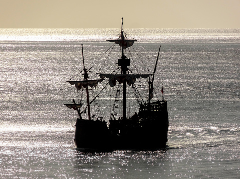 silhouette of a historic sailing ship near Madeira in glittering water ambiance