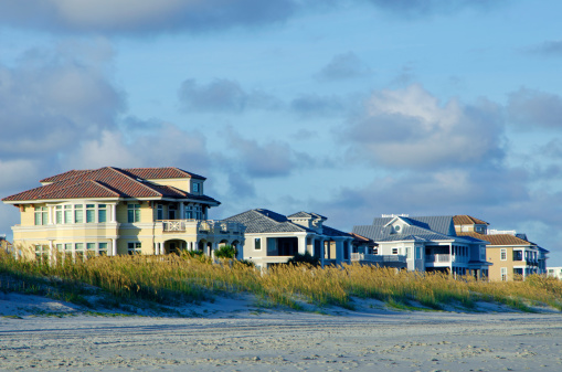 A row of oceanfront, upscale, beach houses. Taken just before sunset with beautiful light and sky.