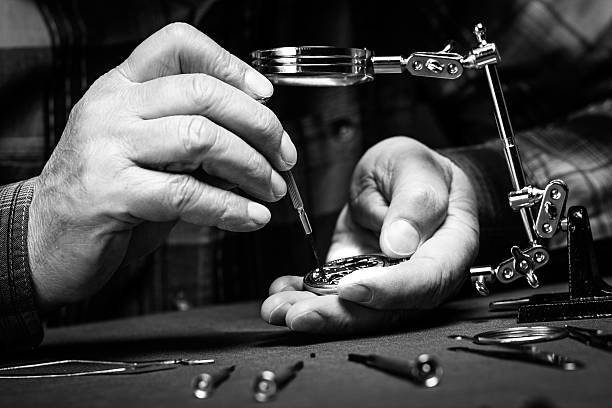 Repairing old pocket watch Pocket watch being repaired by senior watch maker, close-up. Black and white. adjusting photos stock pictures, royalty-free photos & images
