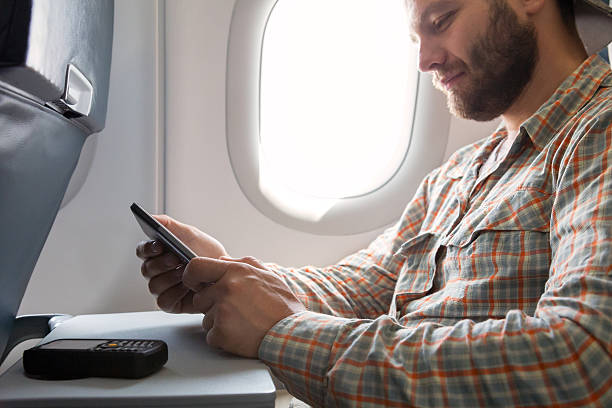 istock Hands of man browsing gadget in aircraft 511514548
