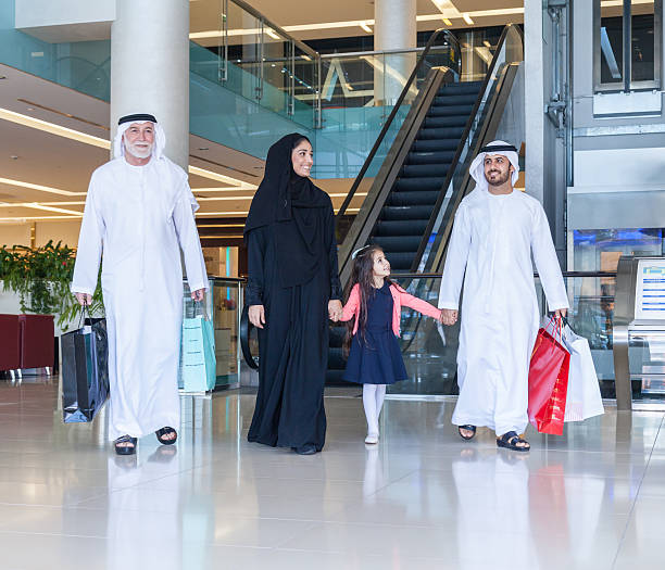 Arabian family in shopping mall Middle Eastern 3 generation Family walking in mall holding hands and smiling middle eastern clothes stock pictures, royalty-free photos & images