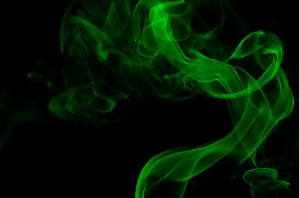 Green smoke forms abstract shapes rising up