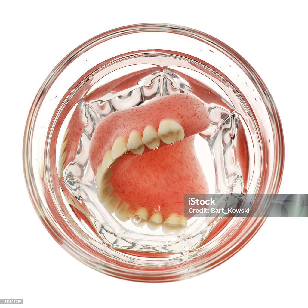 Set of dentures in a glass of water A set of dentures in a glass of water on a white background Arranging Stock Photo