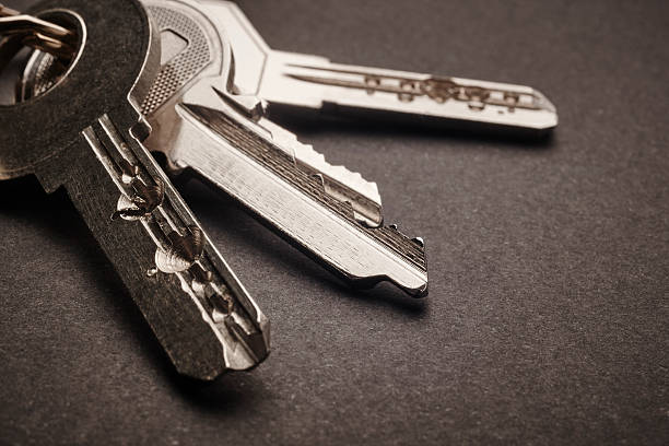 istock Keyring with keys in grey tone over a black background 511526886