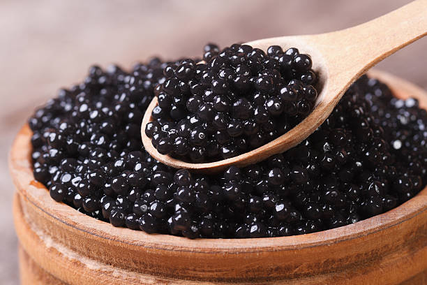 avec caviar d'esturgeon noir cuillère macro. - caviar photos et images de collection