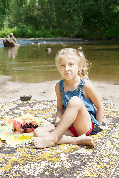 istock Smiling  girl having picknick on the riverside 511530333
