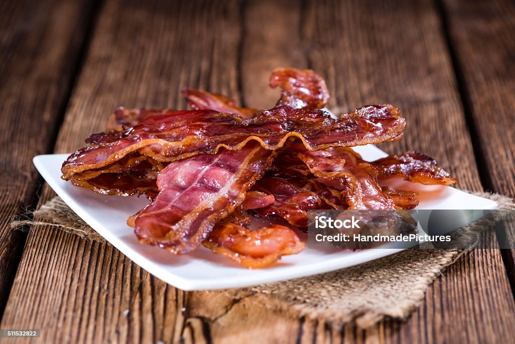 Fried Bacon Fried Bacon (selective focus) on an old vintage wooden table Bacon Stock Photo