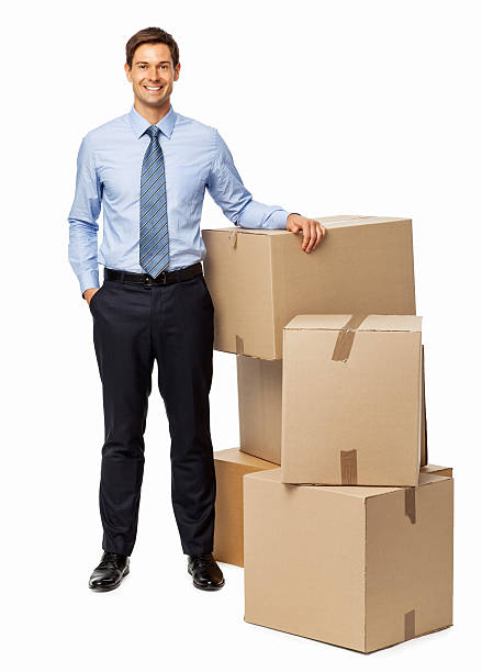 istock Smiling Businessman Standing By Stacked Cardboard Boxes 511534812