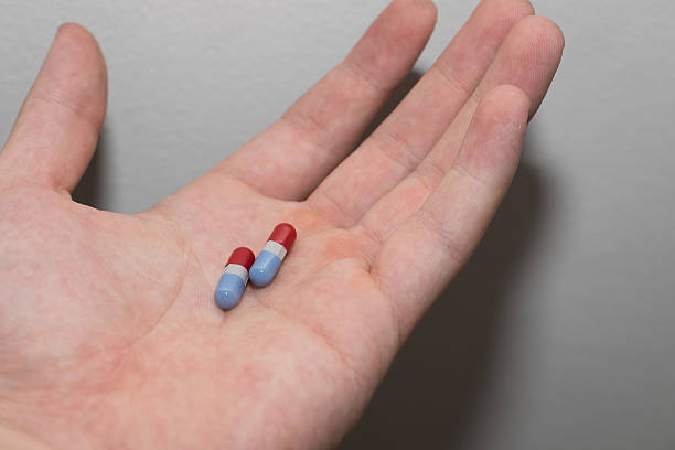istock Red and blue pills in men hand 511536440