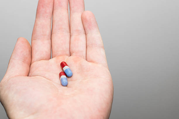 istock Red and blue pills in men hand 511536502