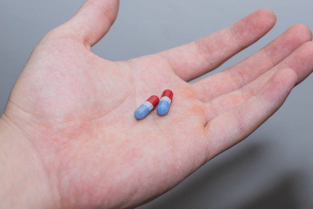 istock Red and blue pills in men hand 511536570