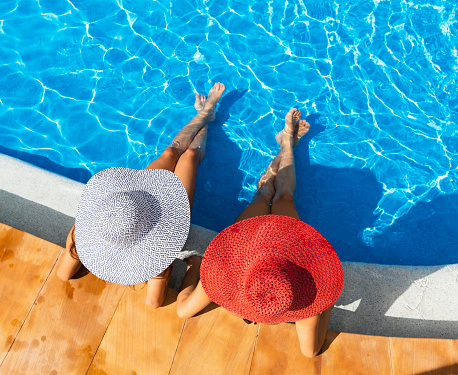 Two woman relaxing in resort swimming pool