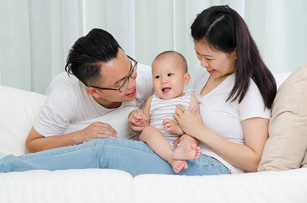 Indoor portrait of asian parent and their baby boy