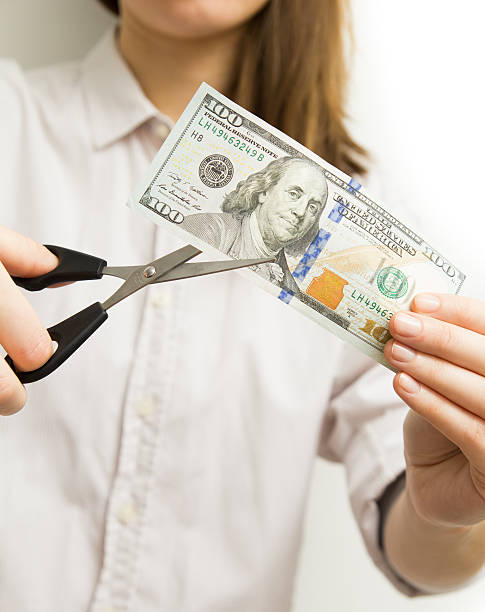 istock Woman cutting dollar bill savings concept 511539088