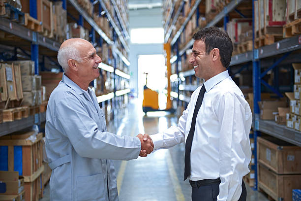 istock Manager and employee handshake in warehouse 511539414