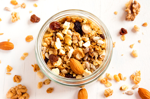 Homemade granola with nuts and seeds in glass jar for healthy breakfast