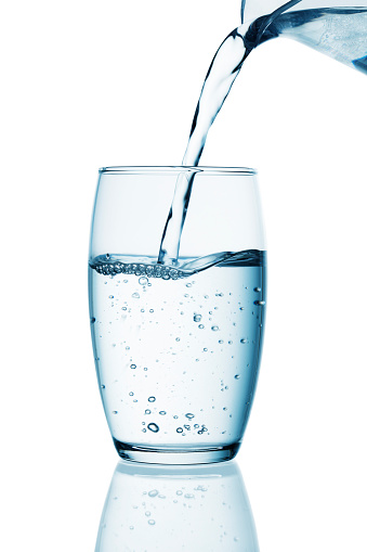 Water being poured from a glass pitcher into a glass-Clipping path