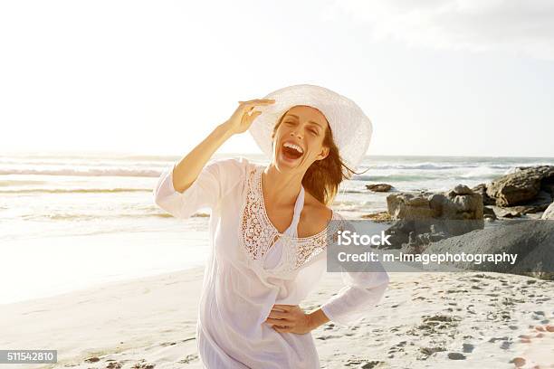 Entspannte Frau Zu Fuß Am Strand In Der Sonnekleid Und Mütze Stockfoto und mehr Bilder von Strand