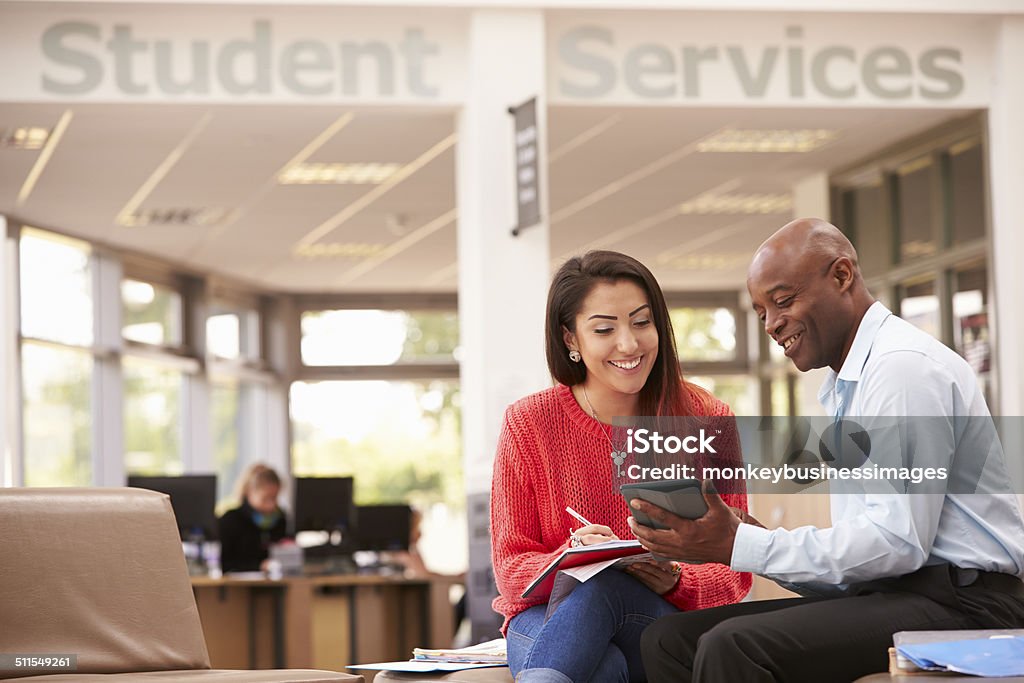 College Student Having Meeting With Tutor To Discuss Work College Student Having Meeting With Tutor To Discuss Work Looking At Digital Tablet Smiling Role Model Stock Photo