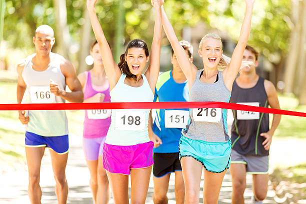 istock Female Marathon Runners Crossing Finishing Line In Park 511551925