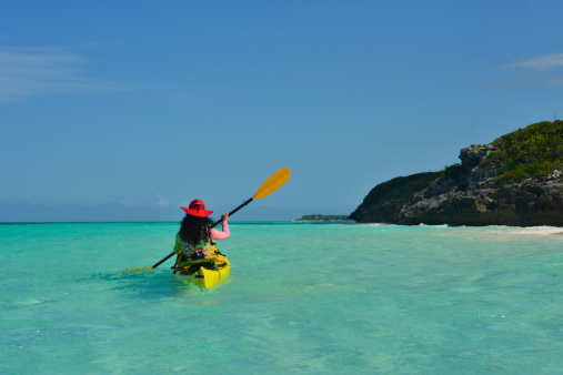 A girl paddles her kayak exploring in Turks and Caicos