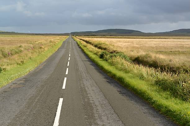 Through Islays peat bogs The road from Bowmore to Port Ellen cuting through miles of peat. bowmore whisky stock pictures, royalty-free photos & images