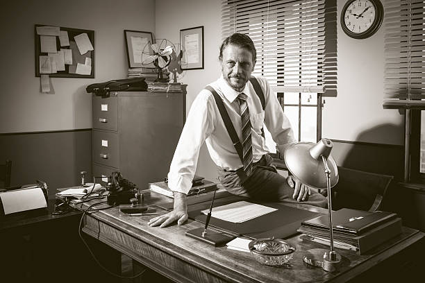 istock Smiling vintage businessman sitting on desk 511579244