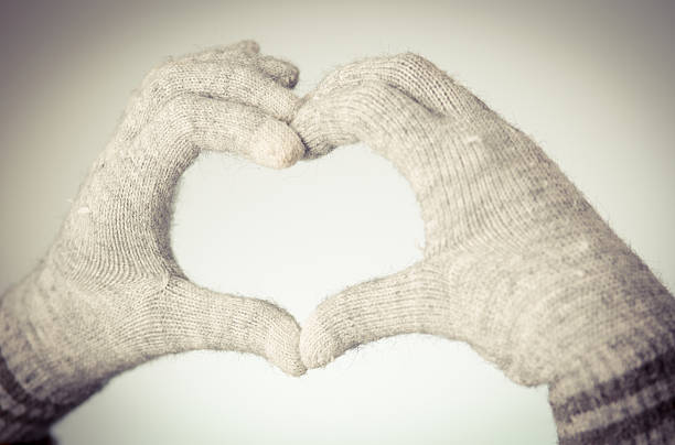 Woman's hands in mitten show heart shape stock photo