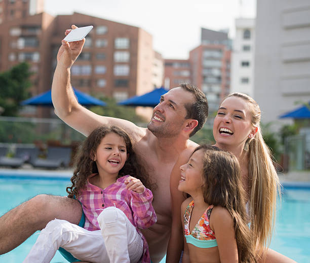 istock Family on vacation taking a selfie by the pool 511581014