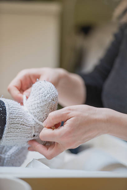 istock Putting wollen baby slippers on baby's feet. 511581154