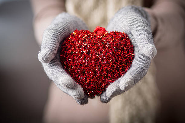 Female hands in mitten with heart stock photo