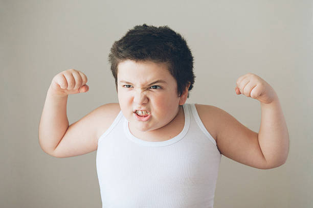 bambino bambino mostrando i muscoli esercizio denti - conflict boxing fighting business foto e immagini stock