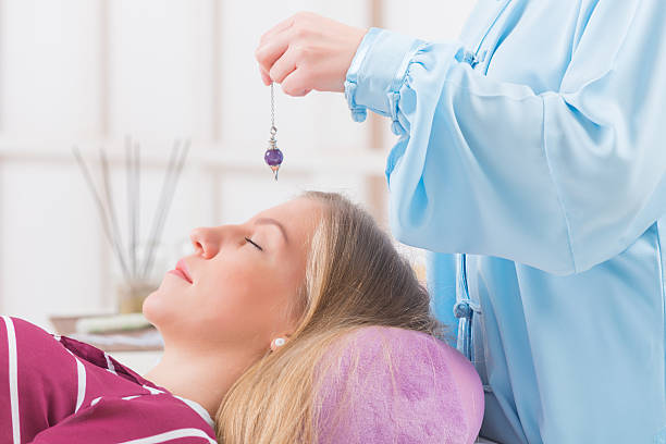 thérapeute à balancier - reiki alternative therapy massaging women photos et images de collection
