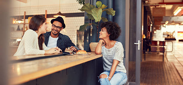 grupo de jóvenes amigos reunión en una cafetería - restaurant review fotografías e imágenes de stock