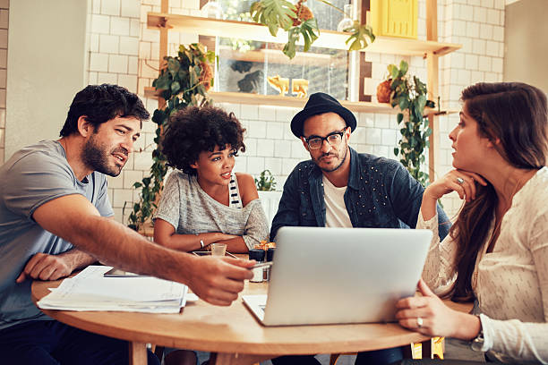 istock Creative team discussing new business project at a cafe 511584896