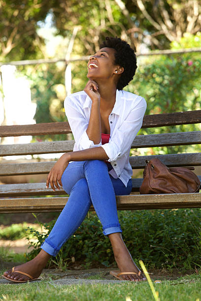 istock African woman laughing on a park bench 511586502