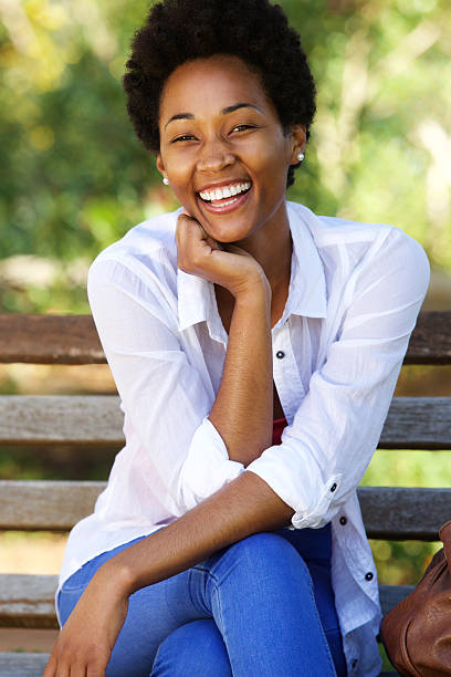 istock Attractive young african woman sitting on park bench 511586958