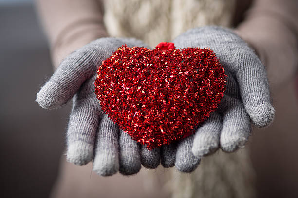 Female hands in mitten with heart stock photo