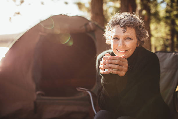 souriant couple mature sur le camping - tent camping lifestyles break photos et images de collection