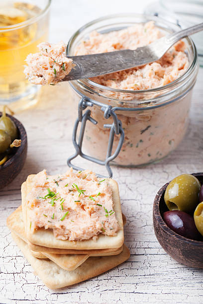 Smoked salmon and soft cheese spread, mousse, pate with crackers Smoked salmon and soft cheese spread, mousse, pate in a jar with crackers, olives and capers on a wooden background tuna pate stock pictures, royalty-free photos & images
