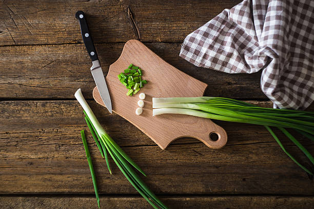 istock Green onions on a chopping board. Knife and napkin 511588198