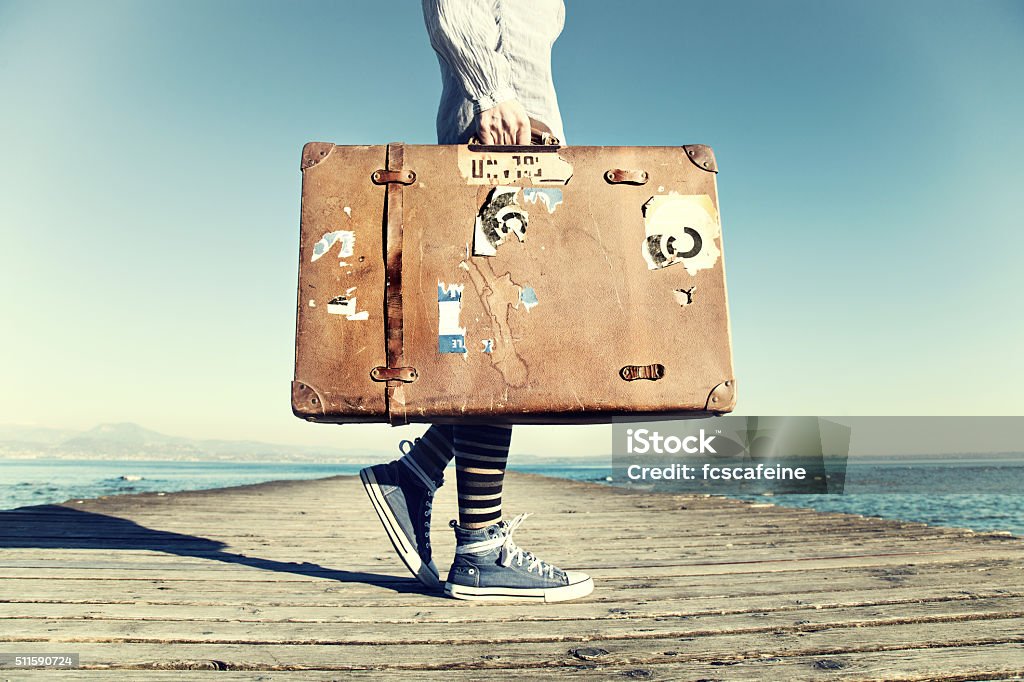 young woman ready to travel with her suitcase traveler woman ready to travel with her suitcase Zen-like Stock Photo
