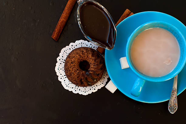 chocolate cupcakes sprinkled with cocoa and a cup of coffee