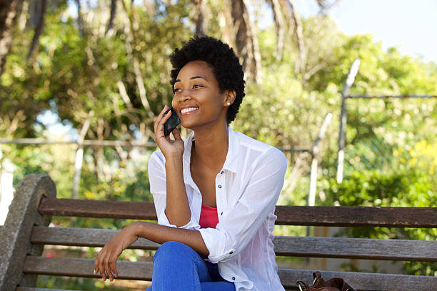 istock Young woman on a park bench talking on mobile phone 511591562