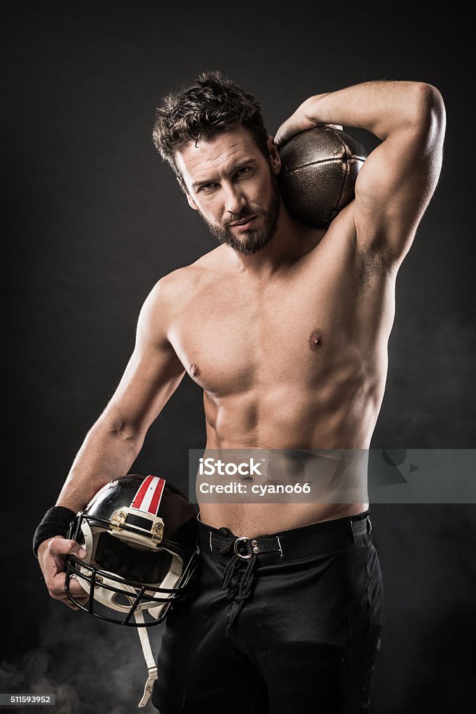 Shirtless football player with helmet Attractive shirtless football player holding protective helmet and posing Men Stock Photo