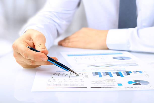 young businessman showing graphs by pen