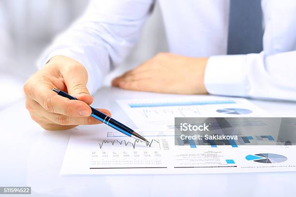 Young Businessman Showing Graphs By Pen Stock Photo - Download Image Now - Number, Privacy, Efficiency