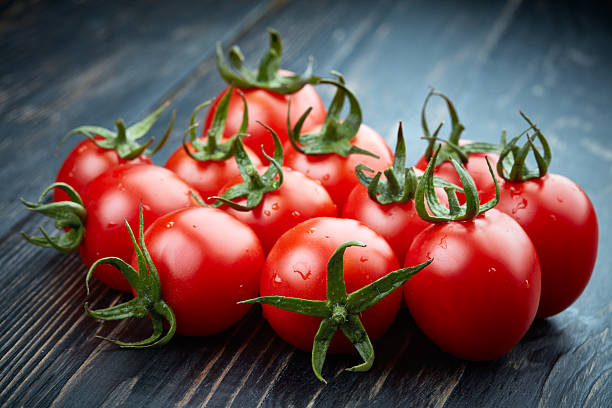 istock Ripe tomatoes on dark wooden background 511594616