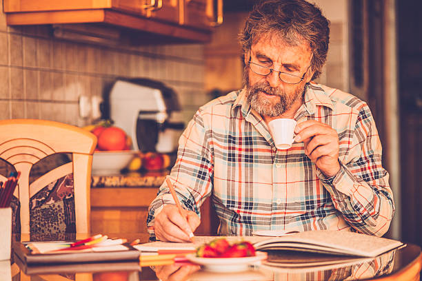 istock Senior Man with Beard Coloring Book and Having Coffee,  Europe 511596340